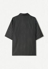 Černá košile s krátkým rukávem a bílými vertikálními pruhy, se špičatým límcem a volným střihem, vyrobena z hladké tkaniny.