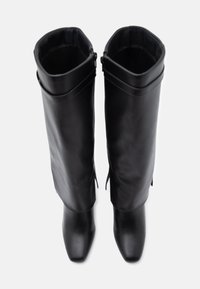 Μαύρες δερμάτινες μπότες μέχρι το γόνατο με λεία υφή, μυτερές μύτες και διπλωμένο μανίκι. Διαθέτουν διακριτική ραφή και πλαϊνούς φερμουάρ.