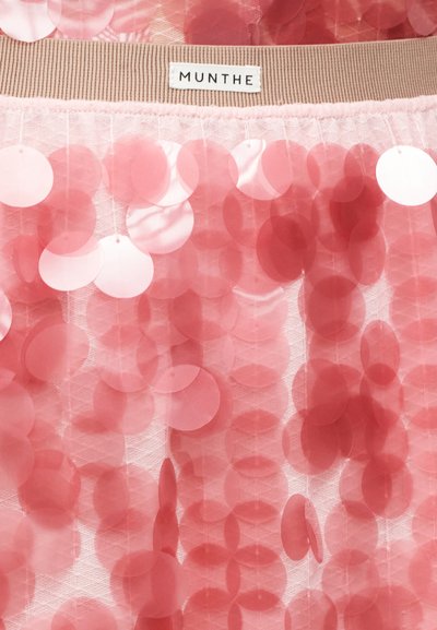 Tissu rose à sequins composé de pièces circulaires brillantes de tailles variées, superposées sur un fond transparent, avec une ceinture tricotée beige portant l'étiquette "MUNTHE".