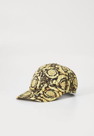 Gorra de béisbol con un patrón floral en negro y amarillo, que cuenta con un visor curvado y un logotipo bordado en el lateral. Fabricada en tela.