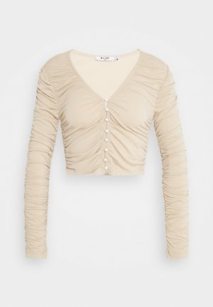 Beige cropped Langarmshirt mit V-Ausschnitt, mit gerafftem Textur und dekorativen Knöpfen an der Vorderseite. Weicher, elastischer Stoff.