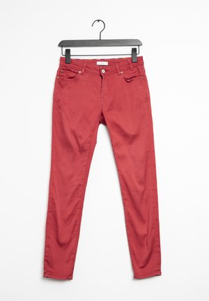 Jeans en coton rouge avec une coupe slim. Comprend des poches avant, des passants de ceinture et une fermeture à bouton à l'avant. Texture lisse, sans motifs.