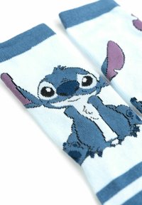 Calzini blu e azzurri con un personaggio dei cartoni animati dagli occhi grandi e dalle orecchie prominenti, realizzati in tessuto morbido e stretch.