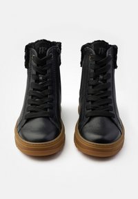 Zapatillas altas negras con un upper de cuero texturizado, que presentan cordones negros, un collar acolchado y suelas de goma marrón. Detalle de cremallera en el costado.