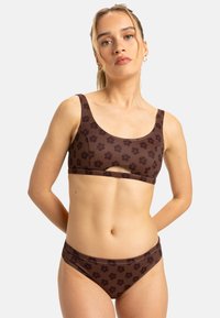 Hnědá bikiny souprava s květinovým vzorem, která obsahuje crop top s výřezem vepředu a odpovídající kalhotky s nízkým pasem. Hladký, elastický materiál s širokými ramínky.