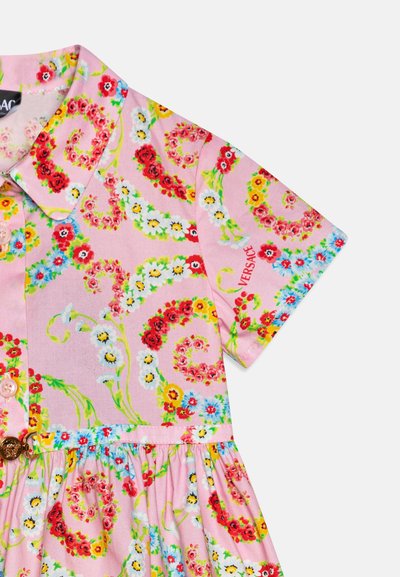 Vestido floral de algodón en color rosa, con patrones en rojo, azul, blanco y amarillo. Los detalles notables incluyen un cuello y un cierre de botones.