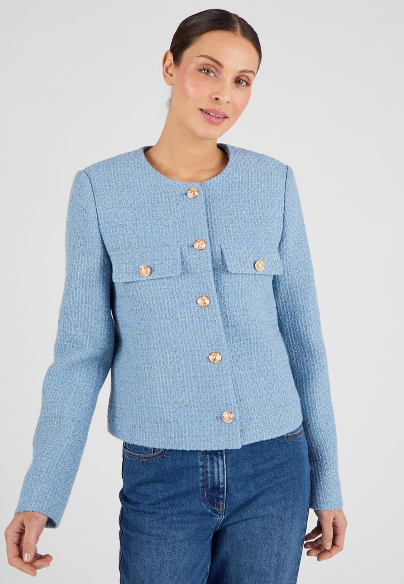Lichtblauwe, gestructureerde jas met een ronde halslijn, vier zakken en gouden knopen aan de voorkant. Lange mouwen met een rechte snit.