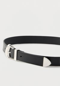 Sort læderbælte med spænde i poleret sølv. Bæltet har en spids ende og pæn syning langs kanterne.