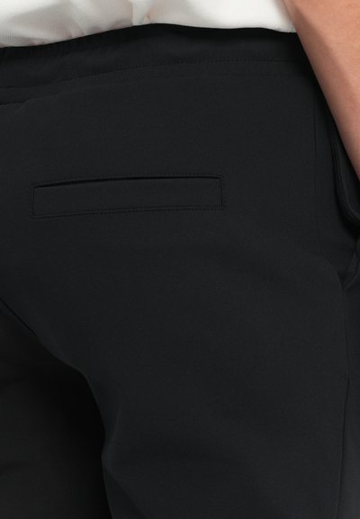 Mustad püksid siledast tekstuurist, millel on tagasihoidlik taga tasku detail. Kanga kaal on kerge ja veidi veniv.