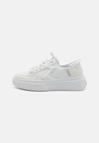 Baskets en cuir blanc avec une pointe arrondie, fermeture à lacets et une semelle épaisse distinctive avec des détails de couture subtils.