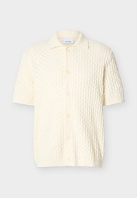 Cardigan en maille crème à manches courtes, motif texturé, col et fermeture boutonnée à l'avant.