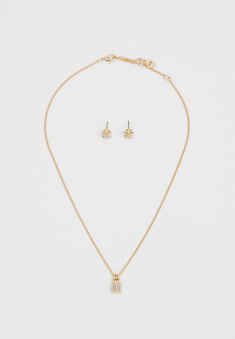 Gouden sieradenset met een delicate kettinghalsketting met een slotvormige hanger en studoorbellen, beiden versierd met kleine heldere stenen.