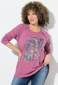 Maglietta a maniche lunghe viola con vestibilità rilassata, caratterizzata da una stampa grafica multicolore testurizzata con la scritta "DANCE MAGIC". Collo rotondo semplice.