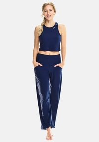 Navy blue athletic crop top and loose-fit pants, stretchy fabric with a smooth texture, and side pockets. Subtle logo on the top.