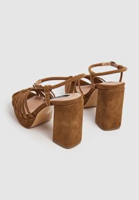 Ruske mokasinske platform sandale s debelim kvadratnim potplatom, sa dizajnom križnih trakica i podesivom anklets trakom za sigurnu poziciju.