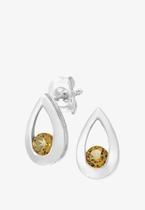 Pendientes de lágrima de plata con una piedra preciosa amarilla transparente en el centro, con un acabado pulido y bordes suaves.