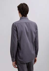 Grijs shirt met lange mouwen gemaakt van zacht materiaal, met een klassieke kraag, knoopmanchetten en een afgeronde zoom.