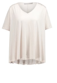 Ljust beige kortärmad V-ringad blus med lös passform och något längre bakstycke, tillverkad av mjukt och lätt tyg.