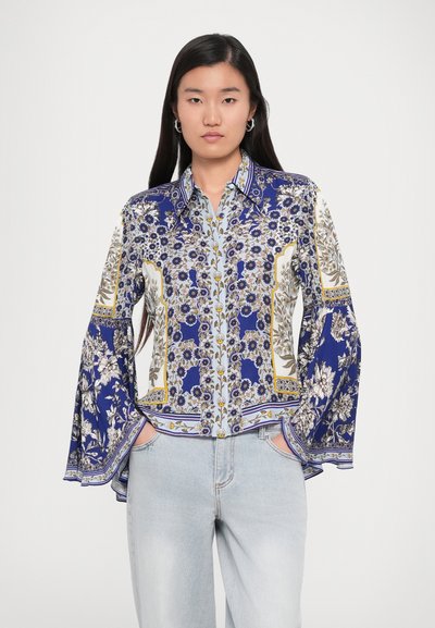 Bluză cu model floral albastru, cu mâneci lungi și evazate. Are un guler la gât și designuri intricate în accente de alb și aur.