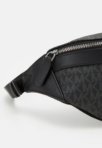 Borsa a tracolla in tessuto nero con motivo monogramma grigio, dettagli in pelle, zip in argento e tracolla regolabile per il massimo comfort.