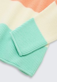 Gebreide trui met geribbelde textuur, voorzien van verticale strepen in koraal, crèmekleur en muntgroen. Manchetten in muntgroene accentkleur.