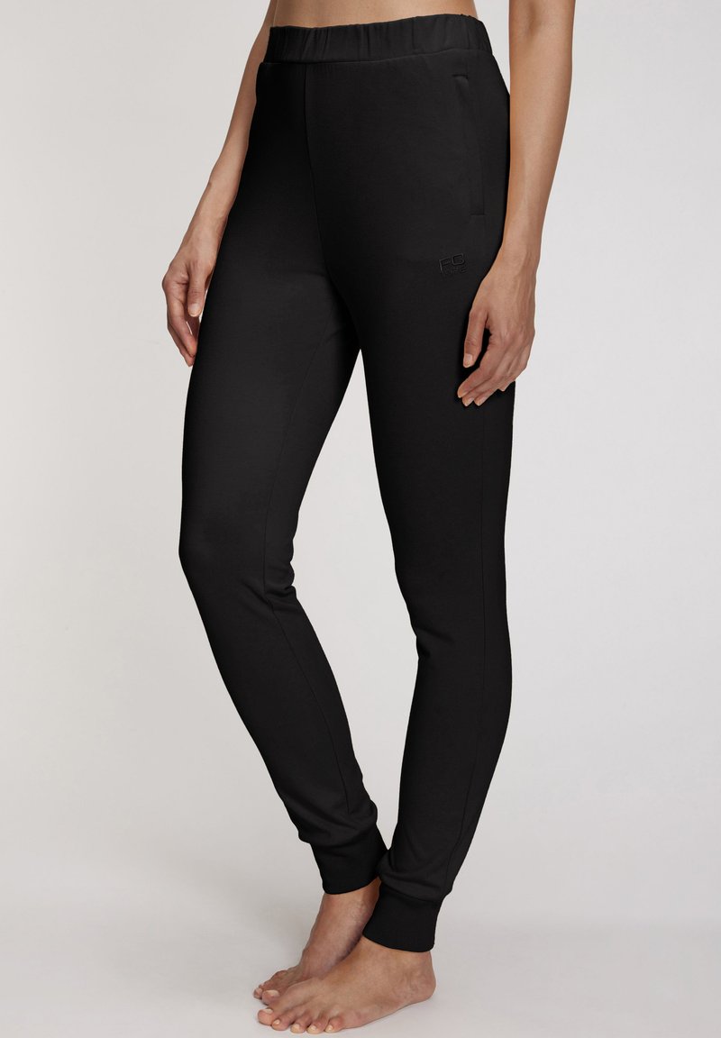 Black athletic pants with a stretchy waist, fitted shape, and ribbed ankle cuffs. Features a subtle logo on the side and side pockets.