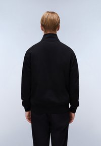 Černá mikina s vysokým límcem, dlouhými rukávy a žebrovanými manžetami, s hladkým povrchem a čistým, minimalistickým designem.