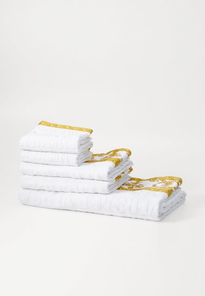 Set of white towels stacked, featuring golden patterned borders and textured surface detailing. Includes three small and two large towels.