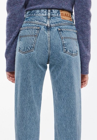 Lyseblå denimjeans med høyt liv, med to baklommer og et brunt skinnmerke på livet.