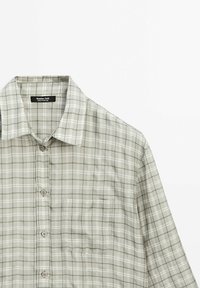 Lichtgewicht, kortge袖dig shirt in een grijs-wit geruit patroon; voorzien van een borstzak en knoopsluiting. Gemaakt van ademende stof.