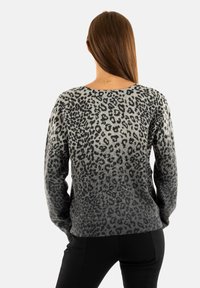 Maglione grigio con stampa leopardata e design sfumato, dotato di maniche lunghe e vestibilità rilassata. Texture morbida con polsini e orlo a costine.