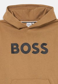 Felpa con cappuccio in cotone marrone chiaro, con un grande logo nero "BOSS" sul davanti e una tasca a marsupio sulla parte inferiore.