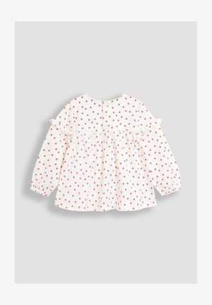 Baltas garām piedurknēm blūze ar rozā punktiņiem, savilktā krūšu daļa, volāni uz pleciem un pogu aizdare aizmugurē. Mīksta kokvilnas auduma.
