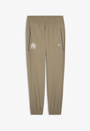 Beżowe spodnie sportowe z elastycznym pasem, z bocznymi kieszeniami, logo Puma oraz emblematem klubu Marsylii w kolorze białym. Gładka faktura tkaniny.