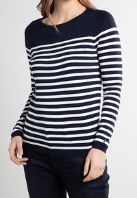 Maglione a righe navy e bianche con maniche lunghe, scollo rotondo e polsini a coste. Realizzato in un tessuto morbido e testurizzato. Vestibilità elasticizzata.