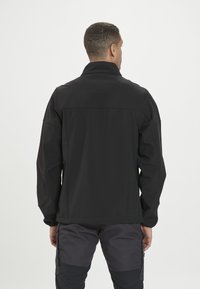 Czarna kurtka softshell z wysokim kołnierzem, długimi rękawami i gładką teksturą. Posiada prosty krój i minimalne detale szwów.