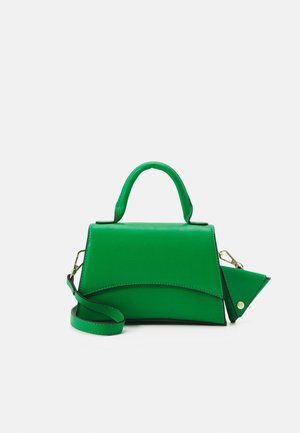 Borsa a mano in pelle verde con manico superiore, tracolla rimovibile e portamonete triangolare attaccato con bottone a pressione, su sfondo bianco.