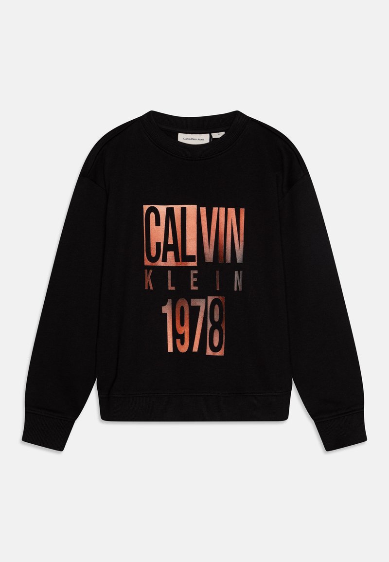Svart hettegenser med en iøynefallende, metallisk rosagull grafikktrykk med "CALVIN KLEIN" og "1978", rund halslinning, og ribbede mansjetter.