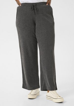 Gray textured wide-leg pants with an elastic waistband and drawstring, featuring side pockets, paired with white sneakers.