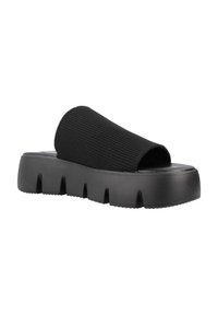 Sandalia negra sin hebillas con una suela gruesa. Presenta un upper de tela texturizada y elástica y un diseño de punta abierta con un acabado suave.