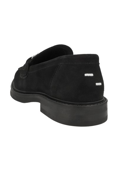 Svart mocka slip-on sko med en strukturerad yta, rundad tå, diskreta vita detaljer vid hälen och en hållbar gummisula.