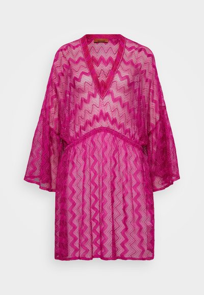 Fuksiaroosa läbipaistev kaftan, millel on sigzag-muster, V-kaelus, laiad varrukad ja kogutud talje. Tekstureeritud kangas voolava siluettiga.