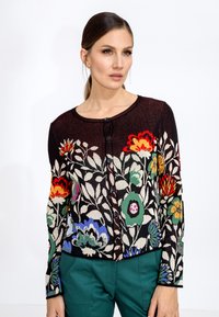 Cardigan en tricot avec un motif floral en fils multicolores sur un fond sombre, avec un col rond et une fermeture à boutons.