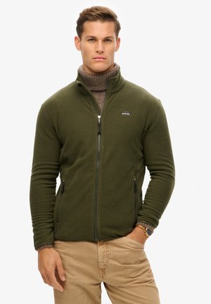 Groene fleece jas met een volledige rits, hoge kraag en twee zijzakken. Heeft ribgebreide manchetten en een klein merkembleem op de borst.