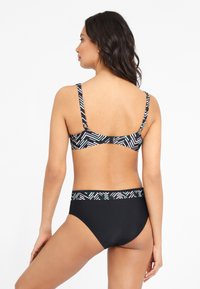 Een zwarte bikini set met een gemusterd top met dunne bandjes en een high-waisted onderkant, versierd met geometrische ontwerpen in wit en turkoois.