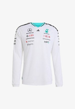 Camicia bianca a maniche lunghe con trama geometrica, dettagli turchesi e vari loghi colorati stampati sul davanti e sulle maniche.