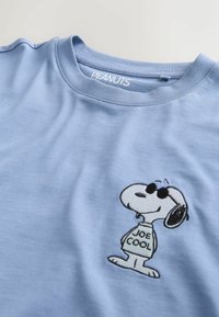 Svetlomodré bavlnené tričko s vyšitým charakterom Snoopyho v slnečných okuliaroch a nápisom "JOE COOL". Klasický dizajn s okrúhlym výstrihom.