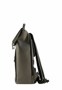 Zaino elegante verde oliva con spallacci imbottiti e chiusura a risvolto, in piedi su uno sfondo bianco.