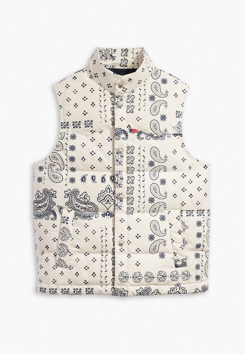 Chaleco acolchado en crema con patrones de paisley y geométricos en azul marino. Presenta un cuello alto, botones a presión y dos bolsillos frontales.