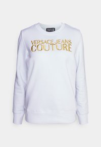 Felpa bianca in cotone con collo rotondo e maniche lunghe. Presenta la scritta in rilievo dorata "VERSACE JEANS COUTURE" sul davanti.